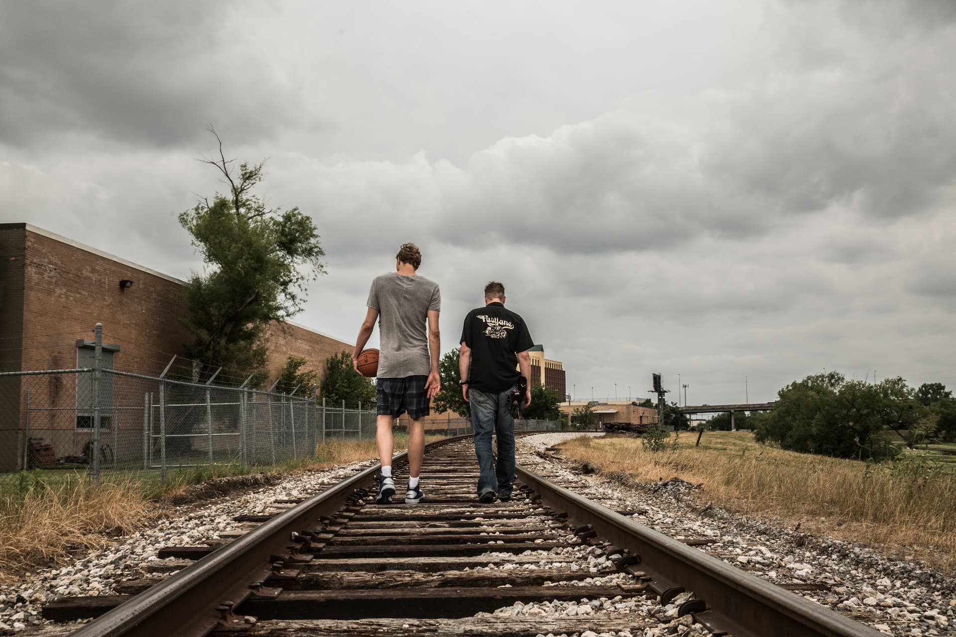 Dirk Novitzki walking along railway tracks with a basketball, alongside Sebastian Siebel